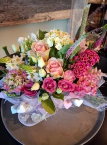  Centre de table floral romantique avec roses et fleurs pastel sur plat rond, présenté lors de l’étape “Accueil et découverte” de l’atelier floral. 